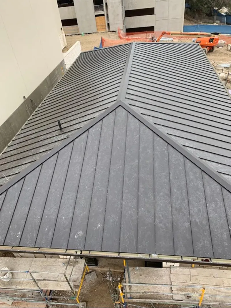 Commercial metal roof construction with crane equipment in Coralville