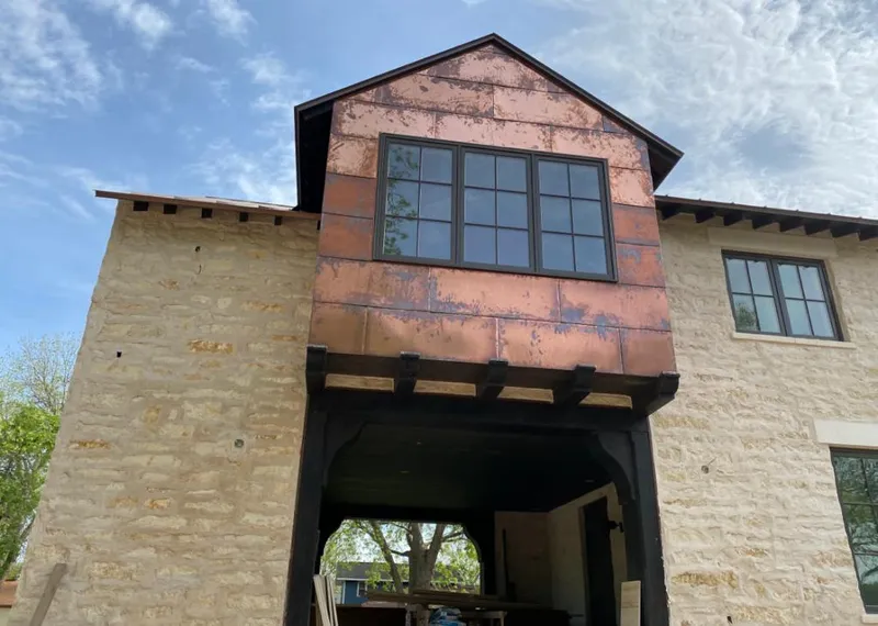 Copper metal panel facade on a stone building for Roof Repair in Coralville